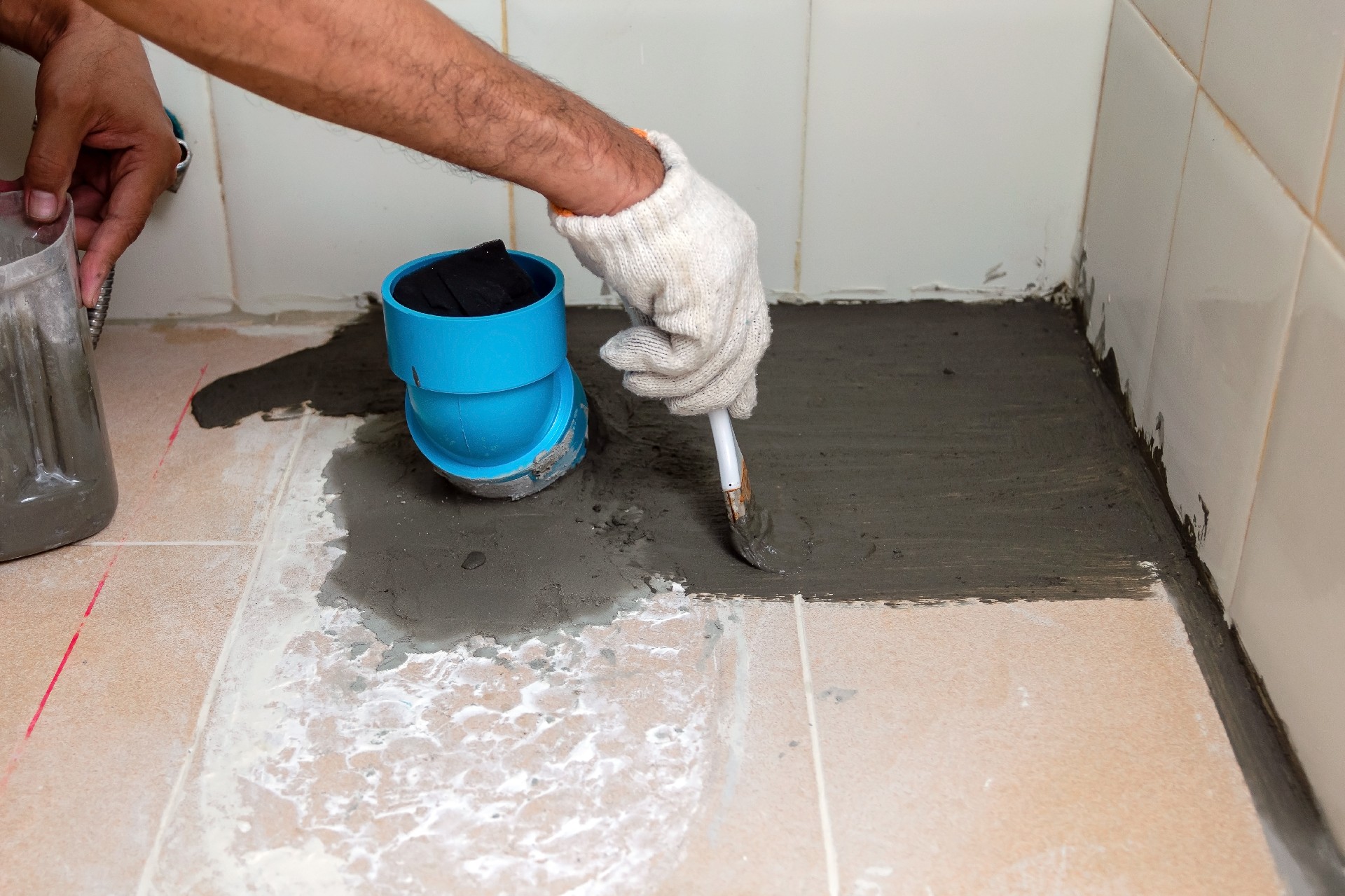 摄图网_307984358_建筑工人正在洗手间瓷砖地板上刷防水泥在清扫安全手动的处理（企业商用）.jpg